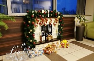 украшение холла в офисе рождественским камином с подарками