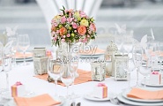 Украшение стола на свадьбу серебряными приборами и цветочной композицией в вазе