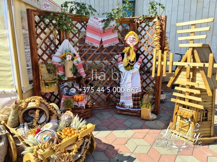 фотозона в национальном стиле с мельницей, телегой, деревянным фоном
