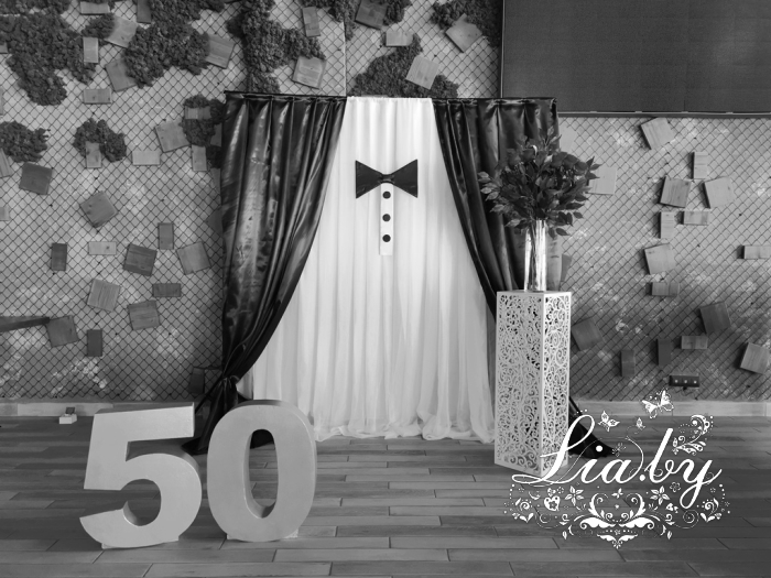 украшение фотозоны на банкете по случаю юбилея в ресторане Астория (Минск, Лебяжий), фотозона в виде костюма с бабочкой, столы украшались высокими вазами с цветами
