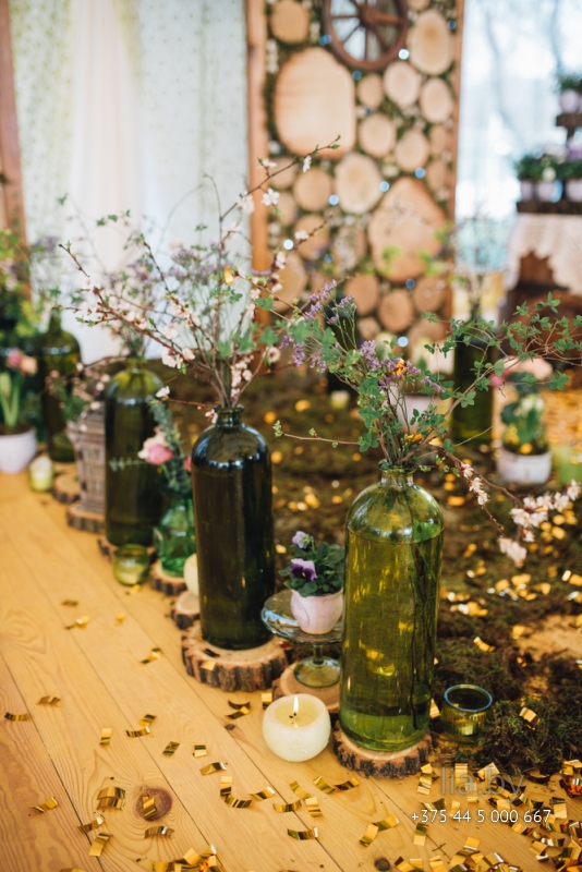Бутылки используются как вазы на свадьбе в стиле рустик