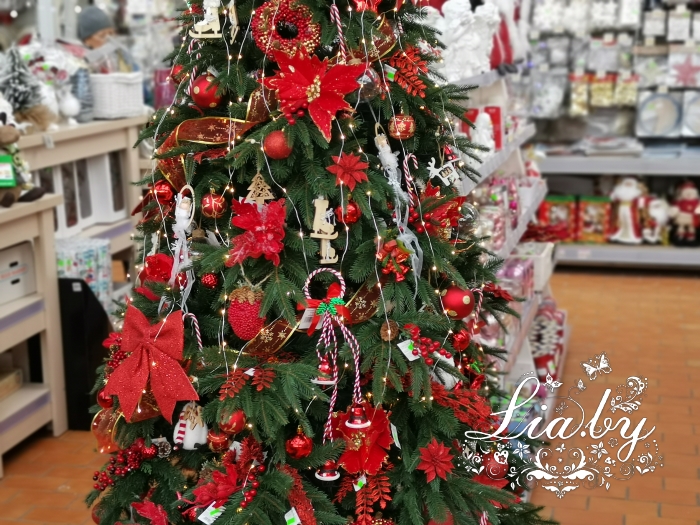 красиво украшенная новогодняя ель с игрушками и светодиодной гирляндой в красном цвете