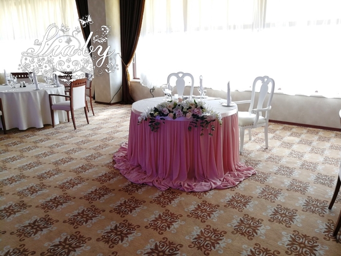 Стол для молодых из кремово-розовой юбки и композиции из цветов на стол