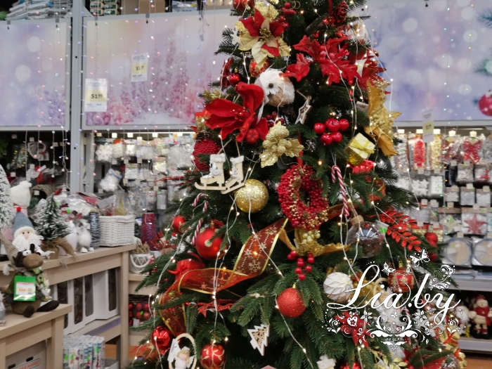 красиво украшенная новогодняя ель с игрушками и светодиодной гирляндой в строительном магазине