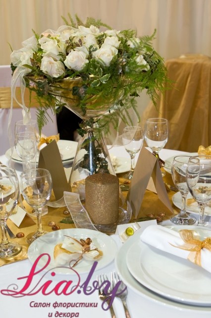 Украшение стола золотым напероном,и вазой с цветами. Чаша вазы в форме бокала для мартини.