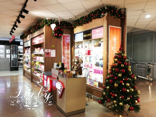 Украшение дьюти-фри магазина конфет к Новому Году: елки, гирлянды, венки