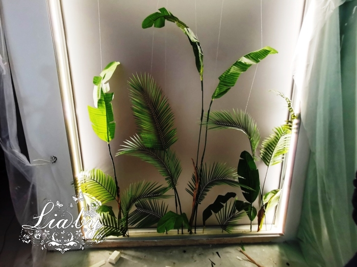 Дизайнерское оформление стены в квартире с использованием искусственной зелени (листья пальмы и фикуса)
