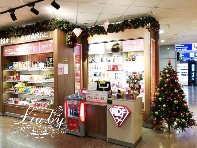 Украшение магазина конфет в аэропорту к Новому Году: елки, гирлянды, венки