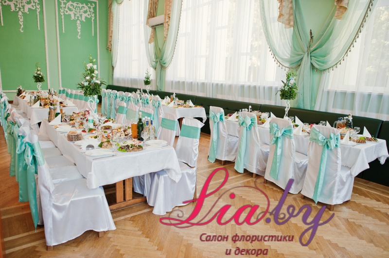 Традиционное оформление банкетного зала на свадьбу: используются чехлы на стулья с бантами в цвет стен зала