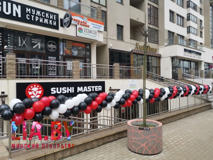 Украшение гирляндой из шаров черного, красного и белого цвета открытия ресторана суши