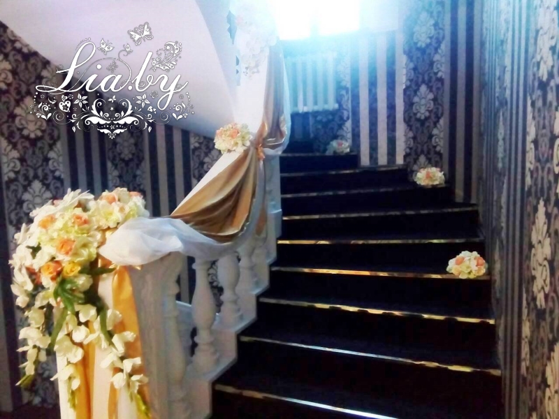 Украшение лестницы в частном доме цветами и тканями в бело-золотом стиле