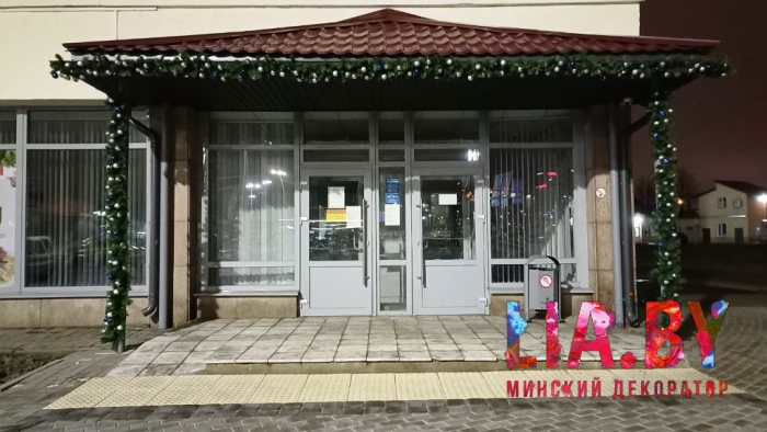 Украшение хвоей с игрушками и светов навесов у входов в отделение Белпочты на Вокзальной площади в Минске