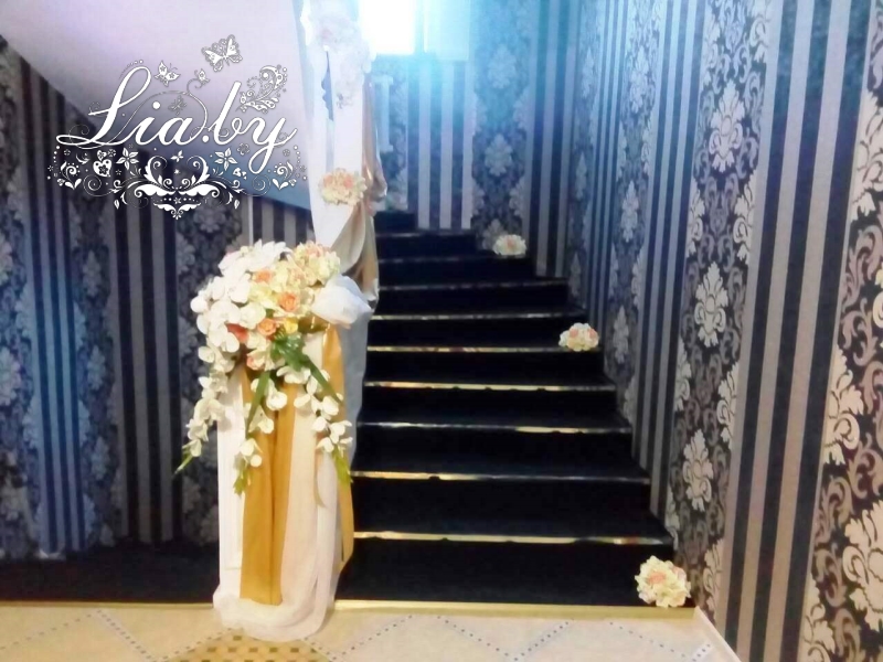 Украшение тканями и цветами в бело-золотом цвете лестницы в коттедже