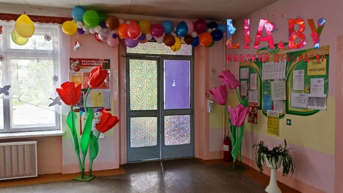 Украшение растяжками с шарами, гирляндой и ростовыми тюльпанами фойе школы на линейку