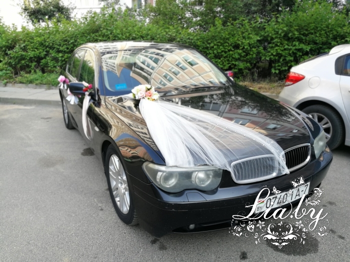 Украшение черного автомобиля на свадьбу фатином и цветами
