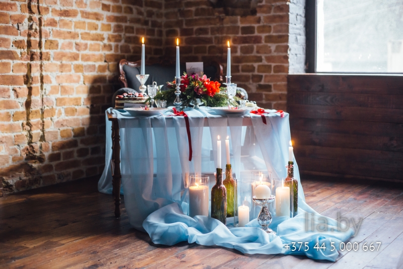 Стильное украшение свадебного стола пустыми стеклянными бутылками со свечами