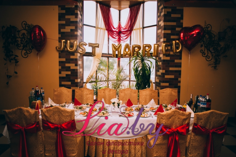 Пышное украшение свадебного зала в золотом и бордовом цвете с использованием цветов, тканей и воздушных шаров