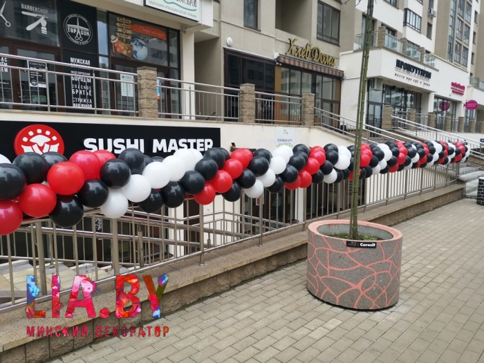 Украшение гирляндой из шаров черного, красного и белого цвета открытия ресторана суши