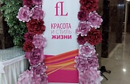 Украшение баннера компании цветами их бумаги на выставочном мероприятии