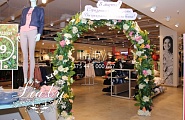 Красивая цветочная арка с зеленью для украшения помещения магазина