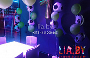 День рождения в телепорте, украшенный воздушными шарами креплёнными вокруг стола. На стене висит фольгированная цифра 7, а рядом стоят фонтаны из шаров среди