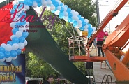 Монтаж гирлянды из шаров на сцену в городском парке на ярмарке (день города)