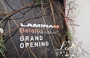 украшение ветвями, каллами и световой гирляндой офиса компании Ламинам - гранит и мрамор - на стене с логотипом ветви