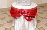 Стол дарения на красной свадьбе в качестве сундука для дарения использован металлический ларчик (можно взять напрокат), стол обвязан красной атласной лентой. Дополнительный декор - красные тюльпаны.