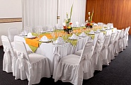 Оформление стульев в белом цвете и цветочные композиции на столе