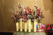композиции в рождественском стиле в высоких вазах цилиндрах с коряжкой, красными листьями, заснеженной хвоей и световой гирляндой