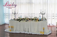 Стол для молодых на свадьбу в белом стиле с цветами и канделябрами, свечами в вазах-цилиндрах